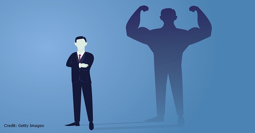 Vector illustration. Business power concept. Businessman standing in front of his own muscular shadow showing his inner strength. Self confidence. Future goal. Self development
